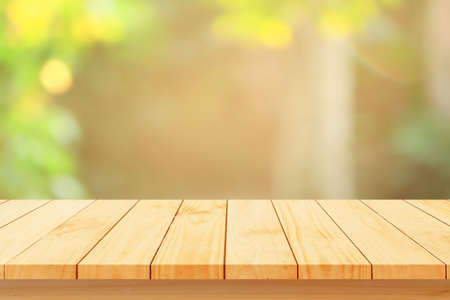Wood floor with blurred trees of nature park background and summer season, product display montageの写真素材