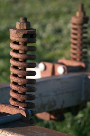 Abandoned farm equipment with rusty springs and boltsの写真素材