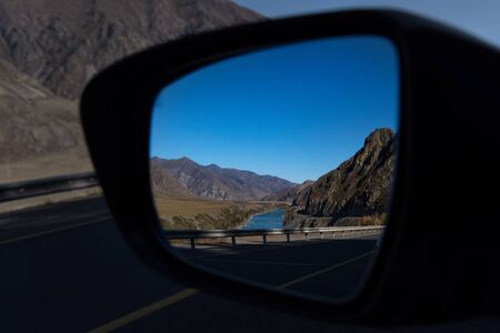 Russia. Mountain Altai. Reflection of the Chui tract in the side mirror of the car near the village of Maly Yalomanの写真素材