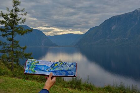 Siberia, Russia. 09/15/2019. Girls-artists draw from nature landscapes of the amazing nature of the Teletskoye lake in the Altai Mountains. Siberia, Russia. 09/15/2019. Girls-artists draw from nature landscapes of the amazing nature of the Teletskoye lakeのeditorial素材