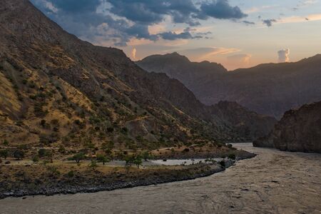 Central Asia, Tajikistan. View from the right coast of the border river Panj on the Pamir mountains...