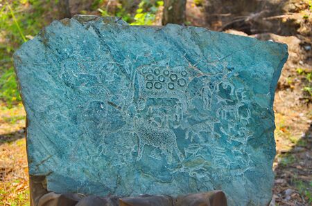 Mountain Altai, Russia. August 10, 2014. The Museum under the open sky on the river Chemal. Petroglyphs are drawings of people and animals carved on rocks, stones, and other hard surfaces that may be more than a thousand years old.のeditorial素材