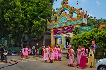 MANDALAY, MYANMAR. November 22, 2016. Young pupils of a convent walk down the street on a parent's...