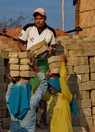 Assam. India February 08, 2016. A small brick factory. Workers accept bricks from clay from young girls and put them in special stacks with holes in the stoves for the subsequent laying of firewood.のeditorial素材