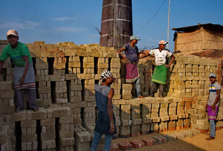 Assam. India February 08, 2016. A small brick factory. Workers accept bricks from clay from young girls and put them in special stacks with holes in the stoves for the subsequent laying of firewood.のeditorial素材