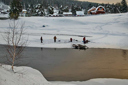 Kebezen, Russia. January 18, 2020. Several fishermen catch grayling on the ice of the Biya river near the village of Kebezen with both summer and winter fishing rods, because the river does not freeze completely.のeditorial素材