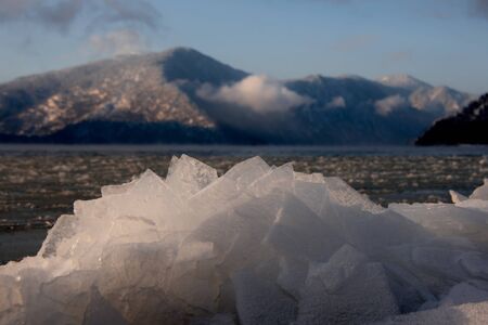 Russia. mountain Altai. Evening light in ice floods and icicles on the shore of lake Teletskoye.