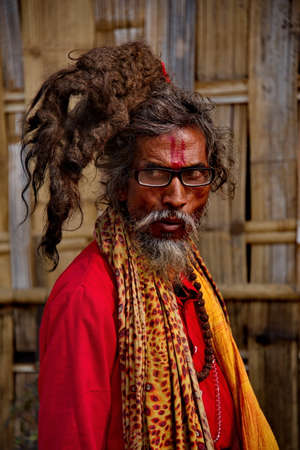 Guwahati. India. February 11, 2016. A pilgrim with an exotic hairstyle on his head in bright clothes is resting before another trip to the Indian shrines.のeditorial素材