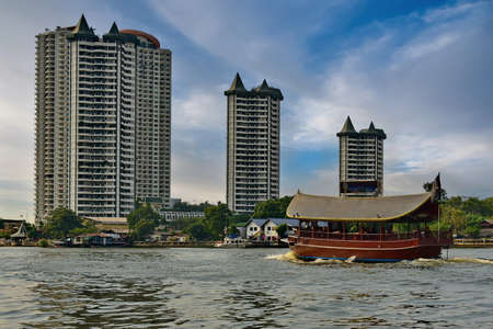 Bangkok. Thailand. December 02, 2016. An excursion water tram sails along the full-flowing Chao Phraya River in the center of the capital. Traditionally, these boats are made in the Buddhist style.のeditorial素材
