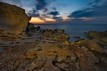 Russia. Dagestan. Dawn on the rocky shore of the Caspian Sea near the city embankment of...