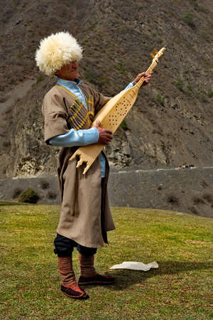 Tlarata. Russia. April 07, 2021. An elderly Caucasian mountaineer in national dress plays the tamur (pandur, dambur). This is a unique two-stringed musical instrument of Dagestan.のeditorial素材