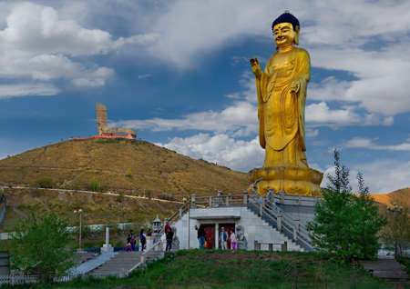 Ulaanbaatar. Mongolia. June, 08, 2015. Golden Buddha statue in the park at the foot of Mount Zaisan with a memorial in memory of the Soviet soldiers who died on the Khalkhin-Gol River.のeditorial素材