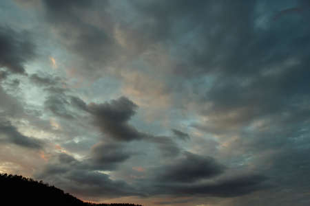 Russia. The South of Eastern Siberia. Gloomy sunset clouds in the evening summer sky over the...