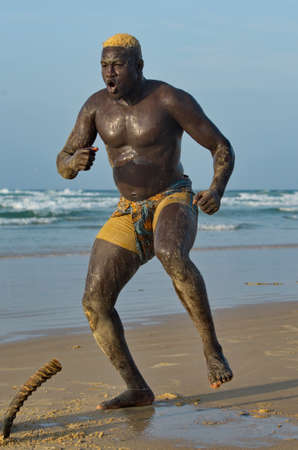 Dakar. Senegal. October 13, 2021. Senegalese wrestling wrestler Laamb on the seashore conducts a ritual ceremony before the fight, showing the opponent strength.のeditorial素材