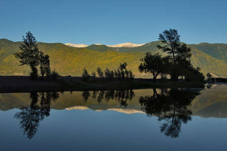 Russia. South of Western Siberia, Mountain Altai. Contrasting reflection of the mountains in the backwater at the mouth of the Chulyshman River in the south of Lake Teletskoye.の写真素材