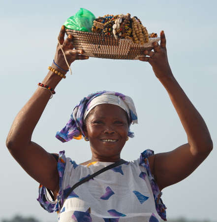 Dakar. Senegal. October 12, 2021. A woman seller from a village on the shore of Pink Lake sells souvenir jewelry, which is on her head in a basket.のeditorial素材