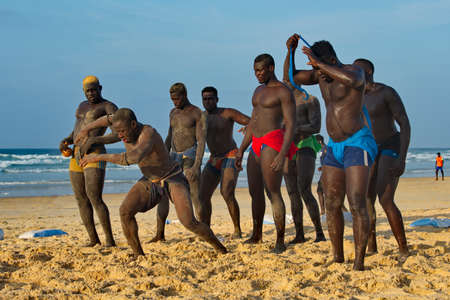 Dakar. Senegal. October 13, 2021. A group of Senegalese wrestling fighters Laamb on the sandy seashore conducts a ritual dance before the fight, showing the opponent strength.のeditorial素材