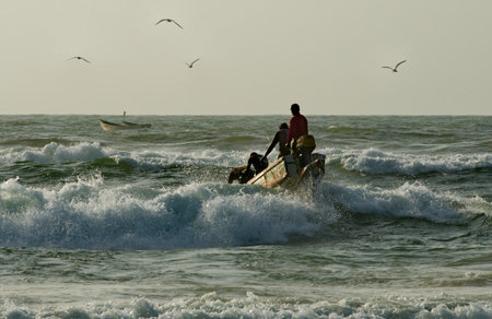 Saint-Louis. Senegal. October 11, 2021. Every day at dawn fishermen on long wooden boats go out to sea fishing with difficulty overcoming coastal waves.のeditorial素材