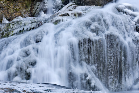 Russia. South of Western Siberia. One of the most beautiful waterfalls of the Altai Mountains on the Karasu River near the village of Chibit on the Chui tract, chained with ice ofの写真素材