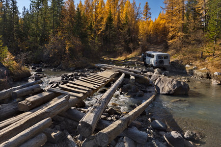 Russia. The Altai Mountains. A dilapidated wooden bridge over the Aktra River, which all-terrain vehicles drive around along the stone riverbed on the way to the ancient glacier ofの写真素材