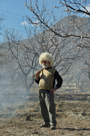 golotl. Russia. April 04, 2021. Portrait of an elderly gray-haired Dagestani man with a hoe, with which peasants cultivate the spring land in the valleys of the North-Eastern Caucaのeditorial素材