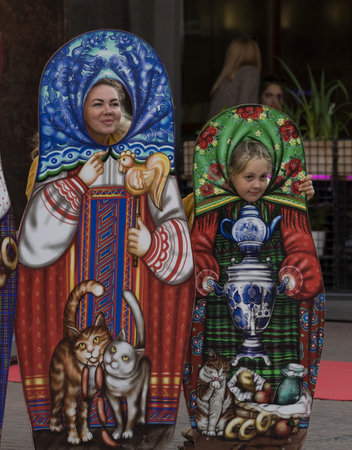 Moscow. Russia. June 08, 2022. A young woman and a girl are preparing for a portrait street photo with colorful decorations in the form of a Russian Matryoshka doll in the park onのeditorial素材