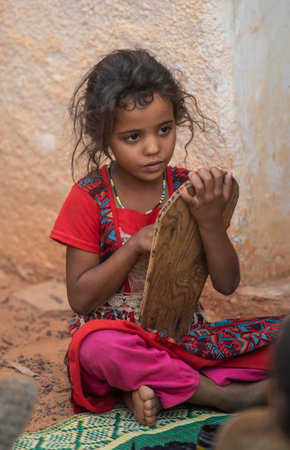 Shingetti. Mauritania. October 05, 2021. Little black-eyed girl are studying in a lesson at a local Koran school. The surahs of the Koran are written on wooden tablets in Arabic.のeditorial素材