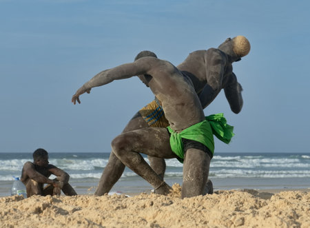 Dakar. Senegal. October 13, 2021. A group of Senegalese wrestling fighters Laamb on the sandy seashore conducts a ritual dance before the fight, showing the opponent strength.のeditorial素材