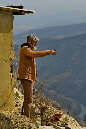 Dubki, Russia. April 03, 2021. An elderly resident of a mountain village shows the expanses of the famous Sulak Canyon in the North Caucasus from a great height.のeditorial素材