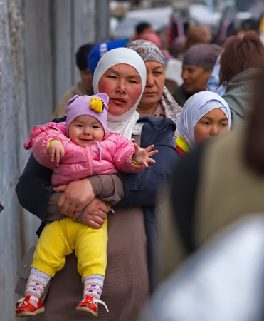 Bishkek, Kyrgyzstan. April 28, 2024. Portrait of a young local woman with a child in her arms at the central city market.のeditorial素材