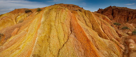 Northern Kyrgyzstan. Picturesque views of the famous Skazka Canyon, the clay mountain peaks of which have bright colors from yellow to red-brown.の写真素材