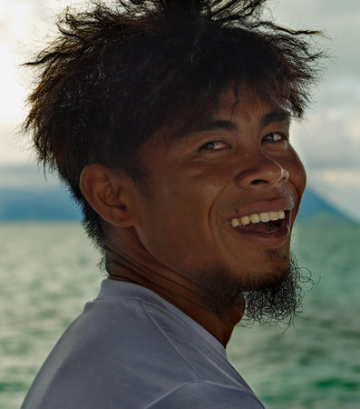 Portrait of a happy young man smiling on the sea background.