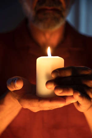 Front view senior man holding candleの写真素材