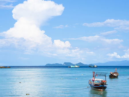 Sea beach view with boats, mountains, cloud and blue sky vacation backgroundの写真素材