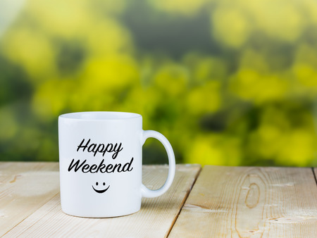 White coffee cup on wood table with blurred green backgroundの写真素材