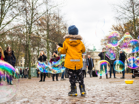 BERLIN - NOVEMBER 19: A kid plays bubble street around Brandenburg Gate on November 19, 2016 in Berlin, Germany.のeditorial素材
