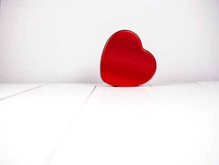 Red heart shape on white wooden backgroundの写真素材