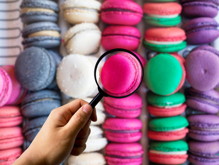 Magnifier handing holding on Macaroons dessert, calories food count diet conceptの写真素材