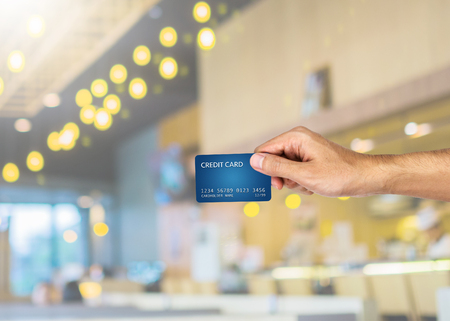 Credit card hand holding with blurred restaurant backgroundの写真素材