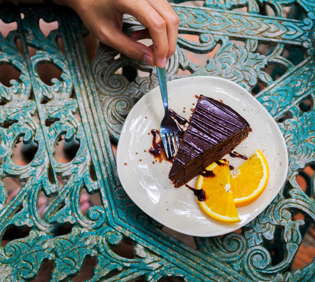 Chocolate cake with hand holding forkの写真素材