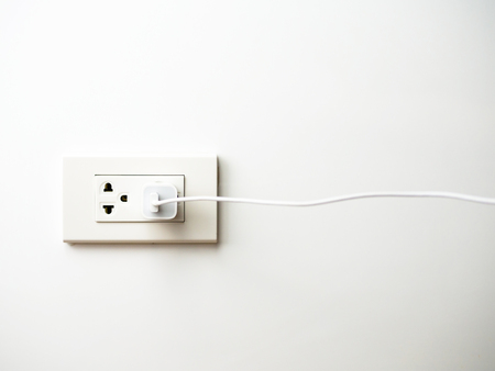 Phone plugged in on socket wall, chargingの写真素材