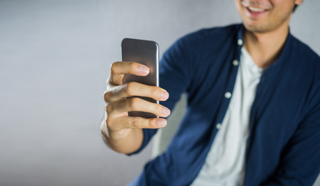 Man using phone, and smilingの写真素材