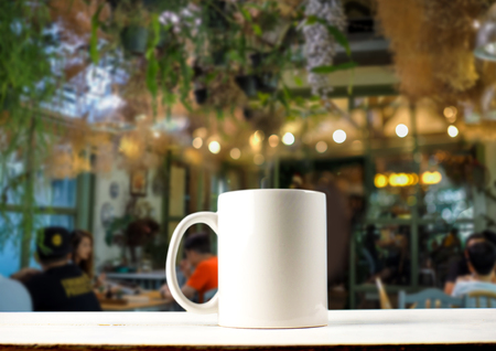 Mug on wooden table with blurry garden cafeの写真素材