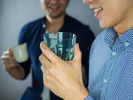 Two men talking and drinkingの写真素材