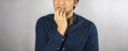 Man making bite nail gestureの写真素材