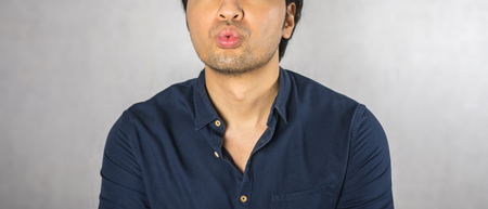 Kiss gesture by man on grey backgroundの写真素材