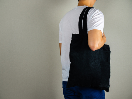 Tote bag hanging by man, standing back