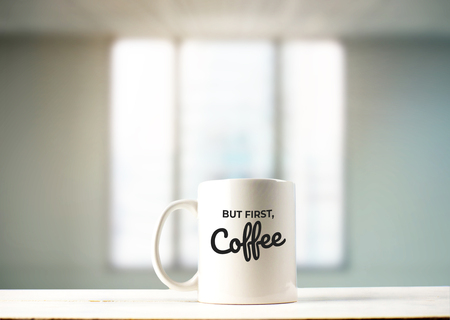 But first, Coffee text on mug in office viewの写真素材