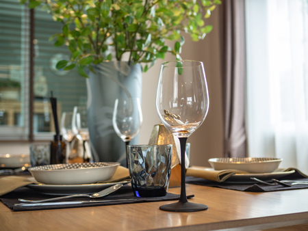 Dinner table setup with empty glass of wineの写真素材