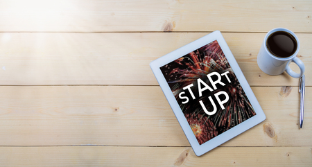 Start up text on tablet on wooden work table